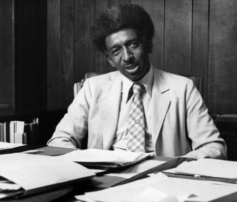 Eugene E. Eubanks sitting at a desk with papers