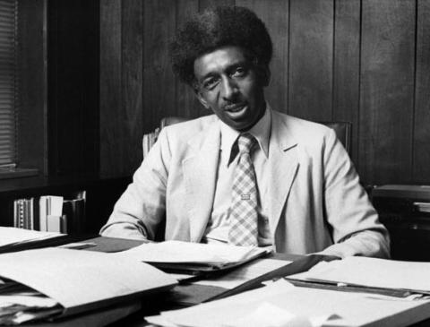 Eugene E. Eubanks sitting at a desk with papers